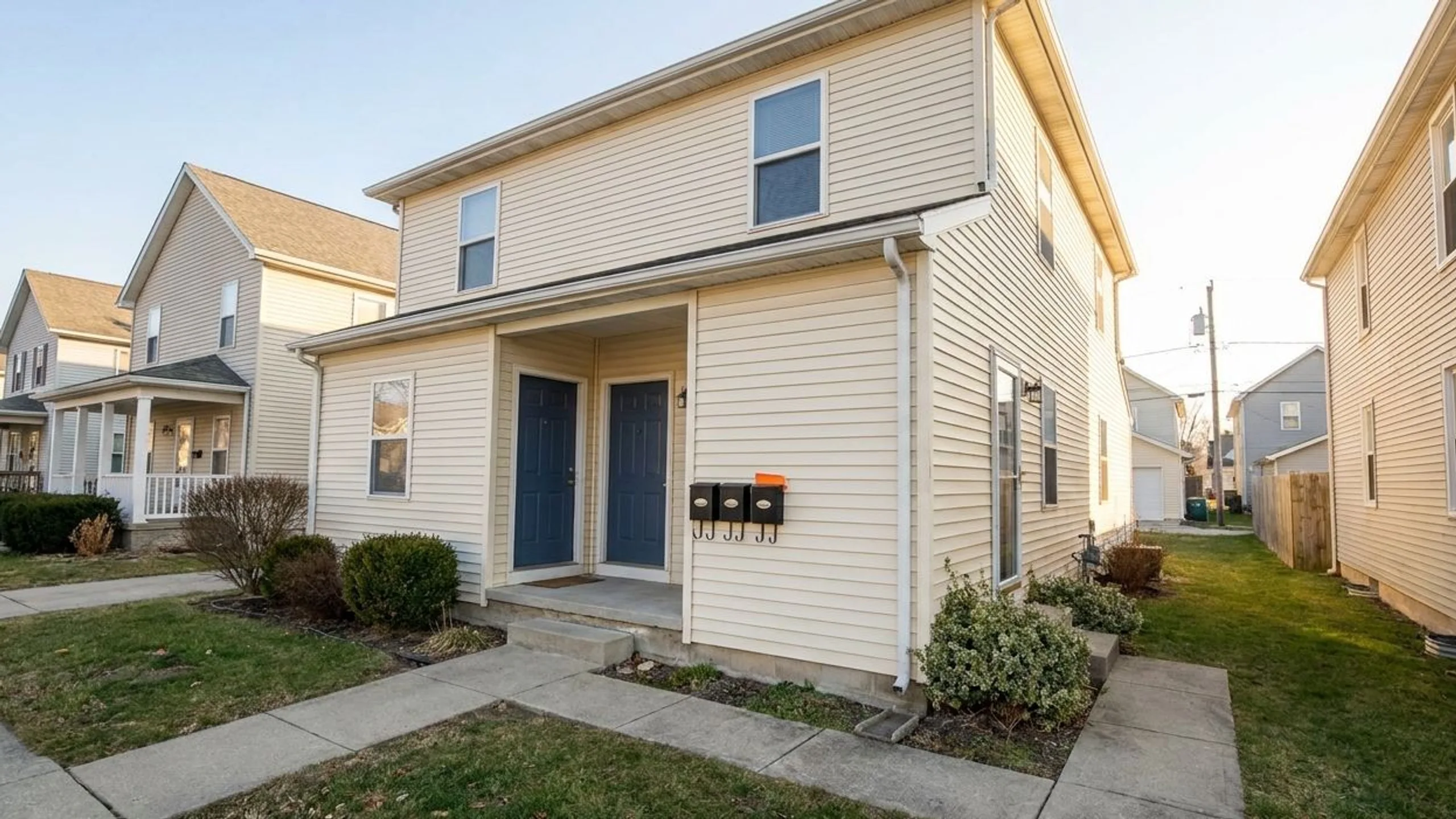 Small duplex or triplex exterior with twin front doors representing house hacking and best cities for house hacking