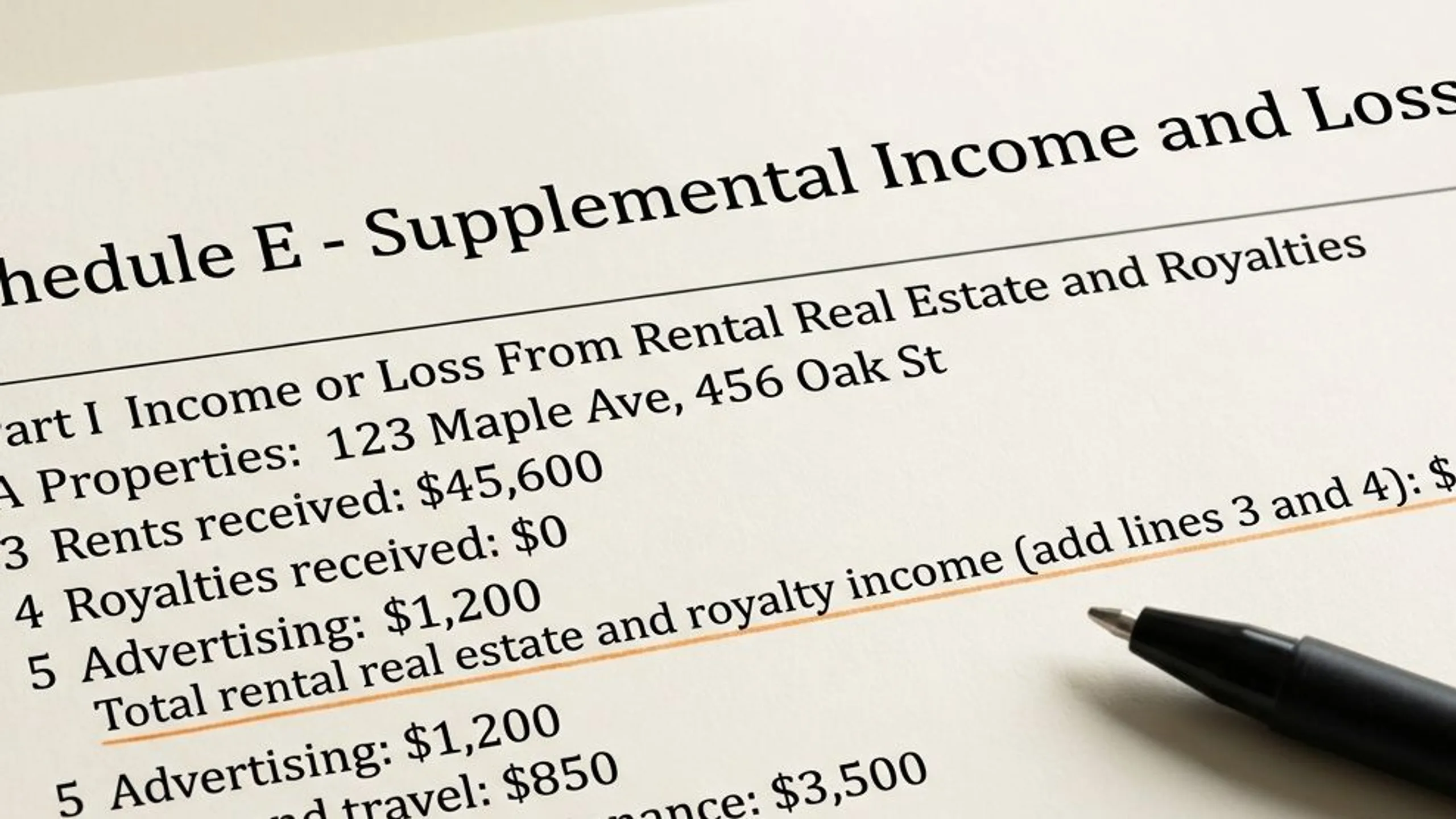Close-up of a printed real estate document for how to find a real with a pen resting on the page