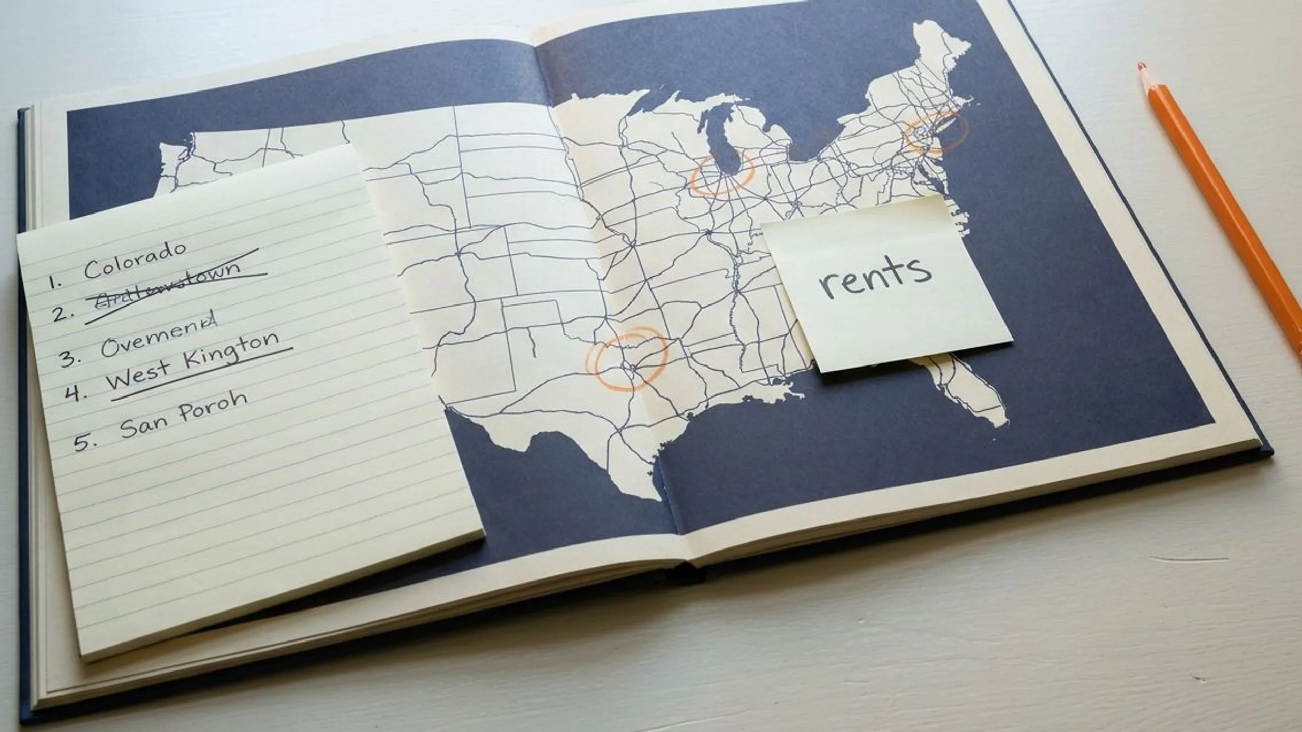 Open paper atlas with circled candidate cities for out of state vs local market research